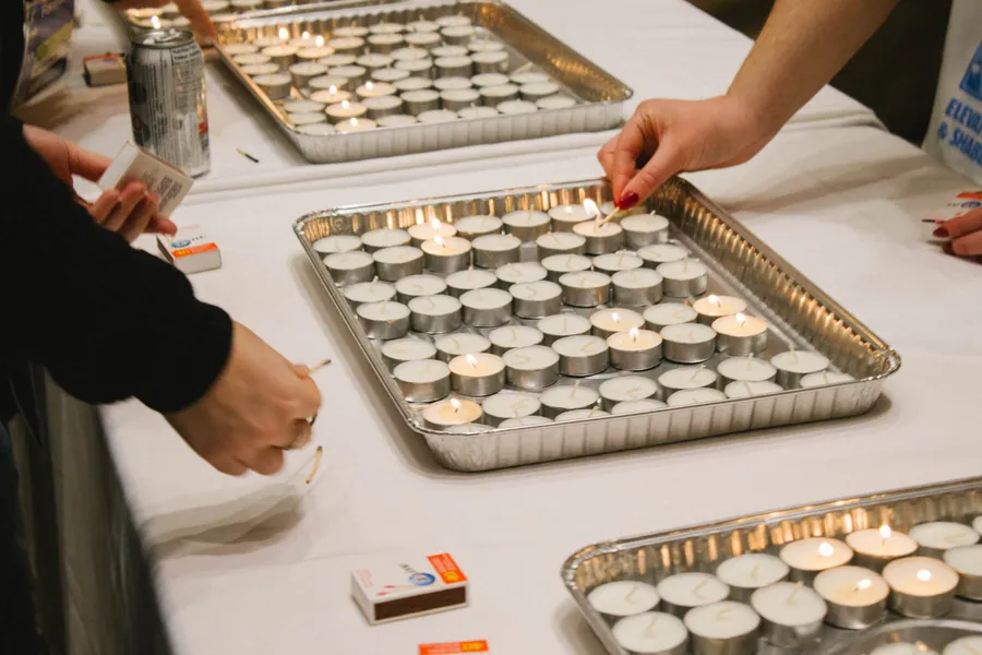 Friday afternoon: tea lights being lit in trays, before Shabbat.